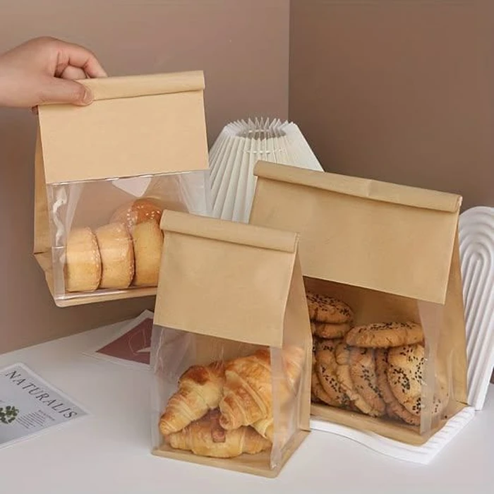 Three sizes of window bakery bag, one held by hand