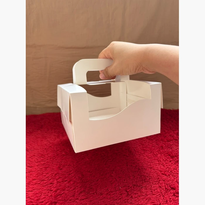A hand carrying the box by its handle